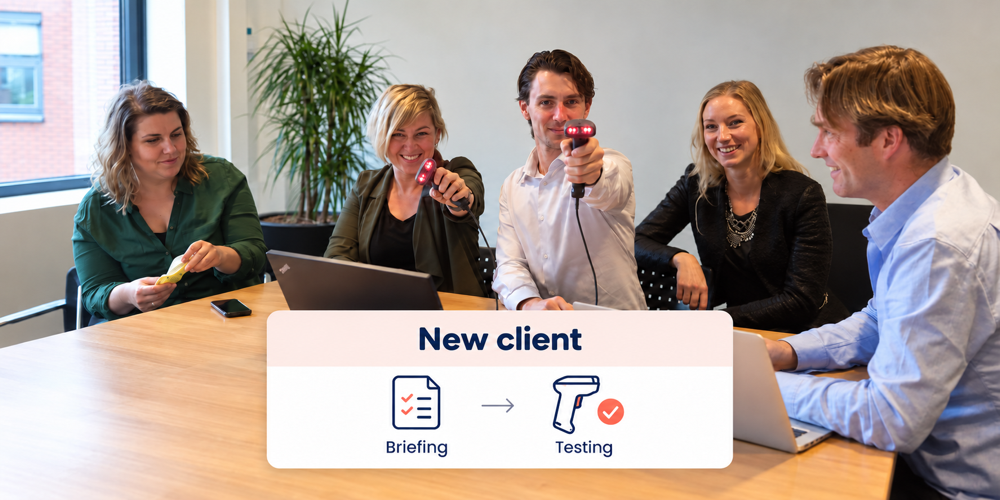 Team at a table with laptops and two handheld scanners, with an overview of briefing and testing for a new client