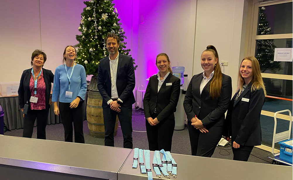 team van hostessen en projectmanager achter de registratiebalie