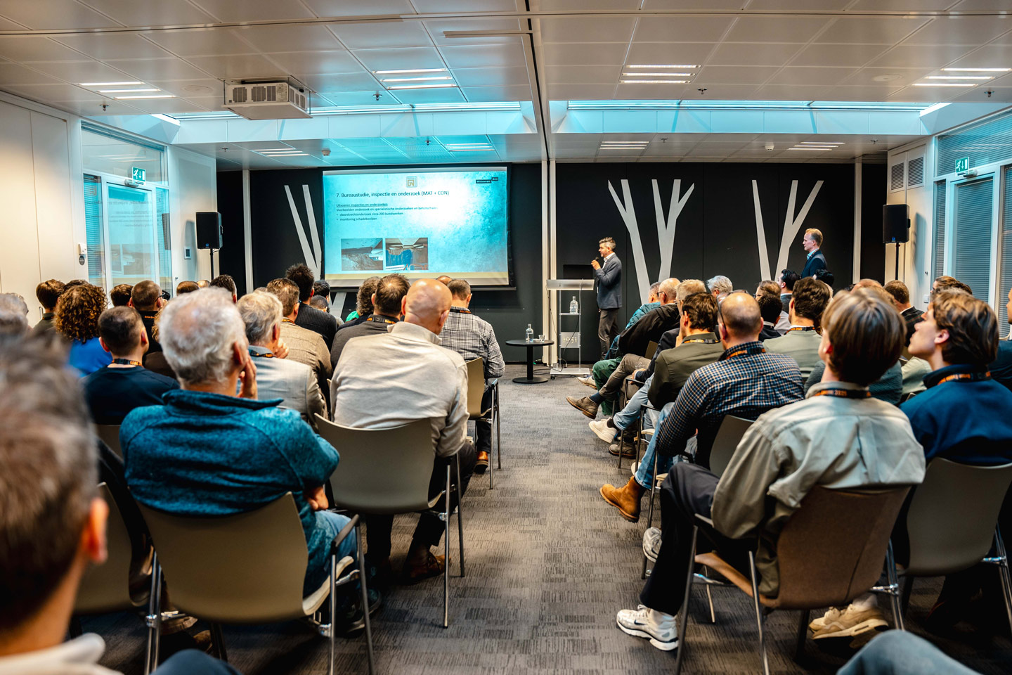 Volle zaal met deelnemers bij een sessie