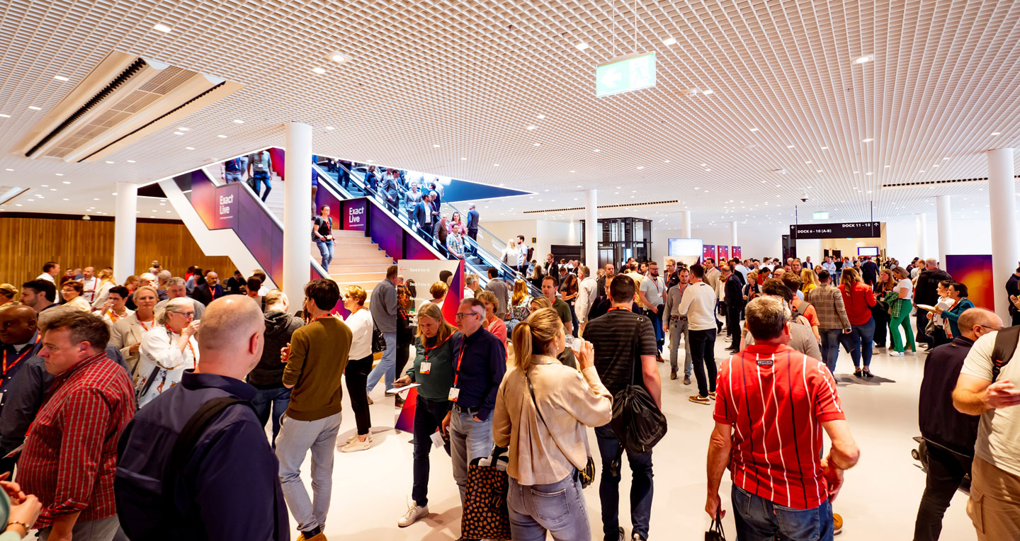 Een drukke beursvloer met meerdere verschillende standhouders en bezoekers.